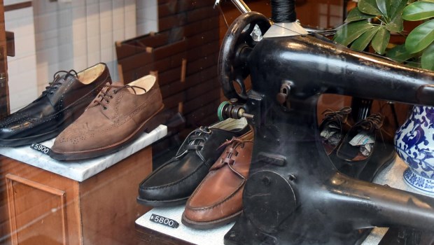 Zapatos hechos en forma artesanal junto a una antigua máquina usada para la confección. Foto Gustavo Carabajal