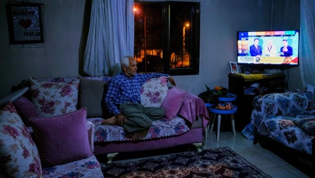 Un residente local sigue los resultados de las elecciones en su casa dañada tras el devastador terremoto.