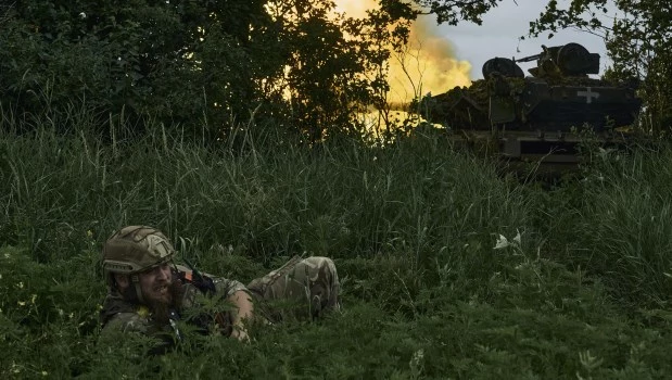 17-6-2023. Un soldado ucraniano yace en el suelo mientras un tanque dispara hacia posiciones rusas en la línea del frente cerca de Bakhmut, región de Donetsk, Ucrania.