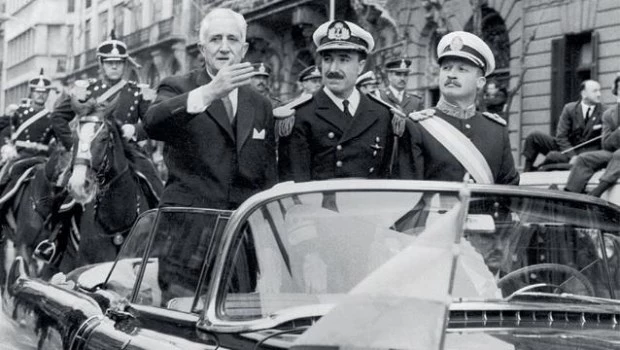 Ya presidente, Arturo Illia desfila junto al militar que lo derrocará, Juan Carlos Onganía (primero a la derecha).