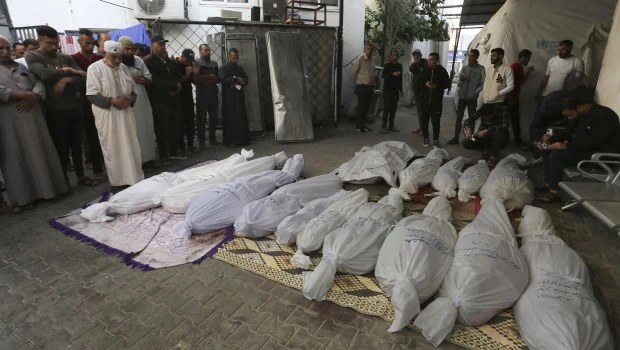 Palestinos rezan junto a los cadáveres de los miembros de la familia Hijazi que murieron en un bombardeo israelí sobre la Franja de Gaza, en Rafah. (AP Foto)