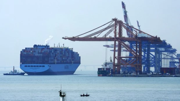 Un barco portacontenedores pasa junto a un grupo de turistas en Xiamen (provincia de Fujian), en el sureste de China.