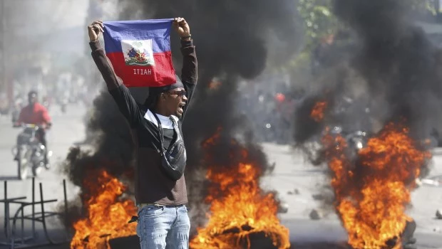 Un manifestante muestra una bandera haitiana durante una protesta para exigir la renuncia del primer ministro del país, Ariel Henry (Puerto Príncipe, Haití, el 1° de marzo de 2024).