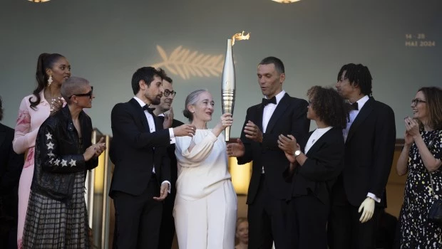 El paso de la llama olímpica por la alfombra roja de Cannes convocó a decenas de fotógrafos y curiosos frente al Palacio de Festivales.
