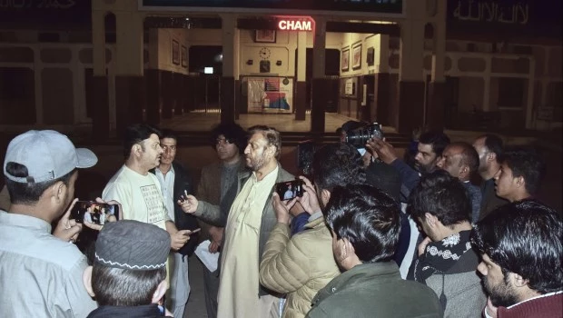 Familiares de los pasajeros del tren atacado por insurgentes frente a una mesa especial para obtener información sobre sus seres queridos en una estación de tren en Quetta, Pakistán