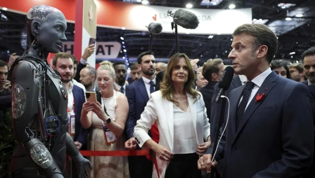El presidente francés observa el robot humanoide Ameca de IVADO Labs durante una visita a la feria VivaTech, dedicada a la innovación y las startups, en París.