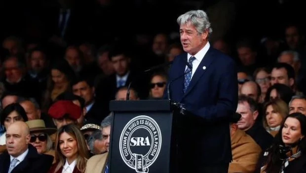 El titular de la Sociedad Rural Argentina, Nicolás Pino en el acto de inauguración de la muesra, con Javier Milei sentado en primer fila.