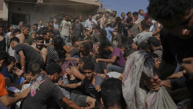 Los gazatíes luchan para alcanzar alguna de las bolsas con ayuda humanitaria.