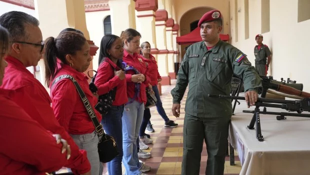 Un miembro de la guardia presidencial muestra armas a quienes se alistaron para unirse a las milicias civiles durante una campaña nacional de alistamiento convocada por el presidente Nicolás Maduro en el museo militar de Caracas