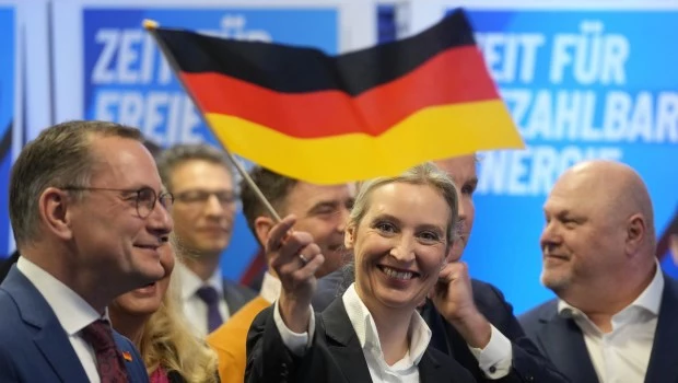 La líder del partido soberanista AfD, Alice Weidel, ondea una bandera alemana en la sede en Berlín.