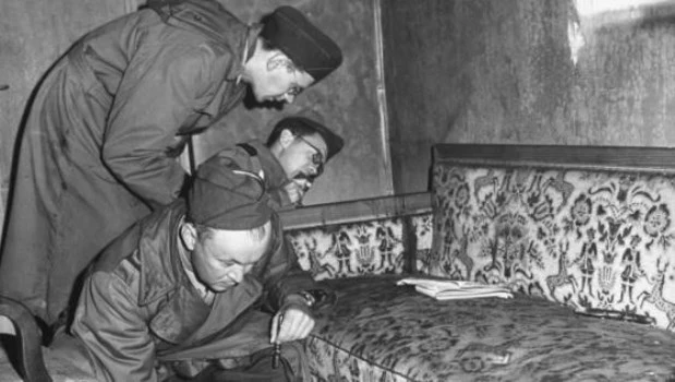 Soldados estadounidenses observando el sillón en el que Hitler se quitó la vida en 1945.