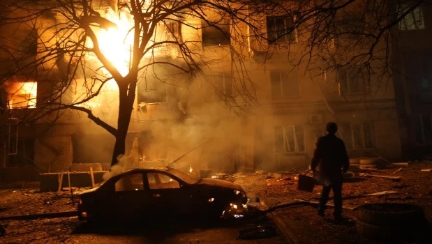 Un hombre camina frente a un edificio residencial en llamas después de un ataque ruso en Zaporizhzhia, Ucrania (26 de noviembre de 2025).