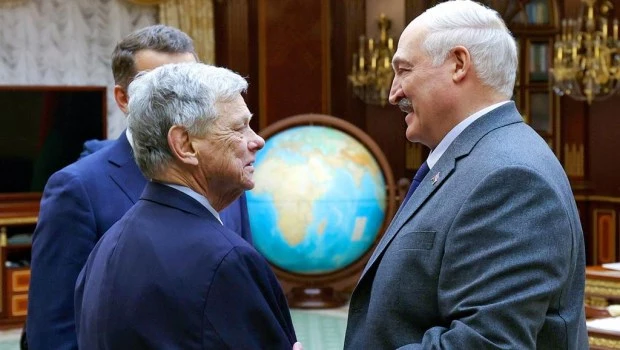 En esta imagen, distribuida por la oficina de prensa del presidente de Bielorrusia, Alexander Lukashenko (derecha) y el enviado de Estados Unidos, John Coale, se dan la mano durante una reunión en Minsk, Bielorrusia, el 12 de diciembre de 2025.