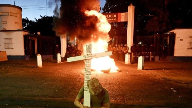 Un policía sostiene una cruz durante una manifestación en reclamo a los incrementos salariales y mejores condiciones laborales, frente a la Jefatura de Policía de Santa Fe, en Rosario.