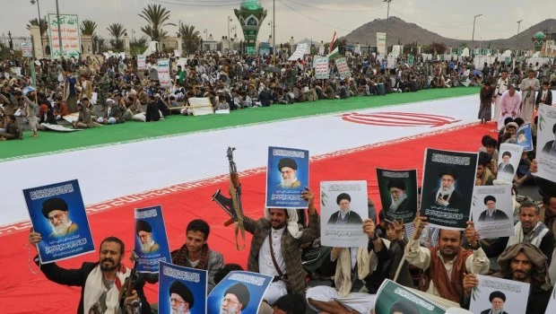 Milicianos hutíes portan carteles con la imagen de Jamenei padre.