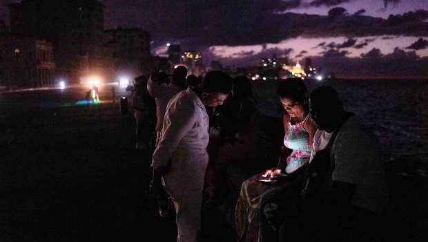 Gente que pasó la noche en la oscuridad en el Malecón durante un apagón en La Habana, Cuba. EFE