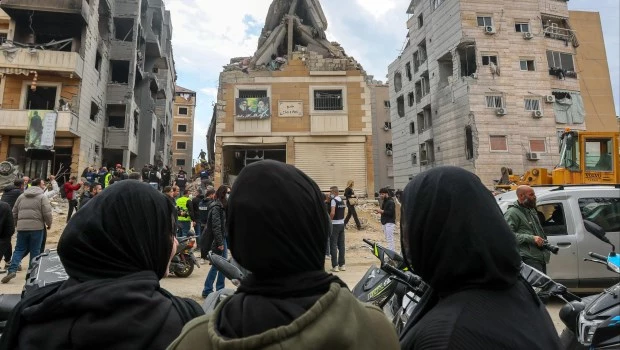 Un grupo de personas observa los daños en un edificio bombardeado en Beirut.