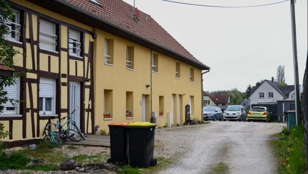Vista exterior del edificio y área de estacionamiento donde fue rescatado el niño de 9 años que había permanecido encerrado en la furgoneta de su padre desde 2024, en Hagenbach, Francia.
