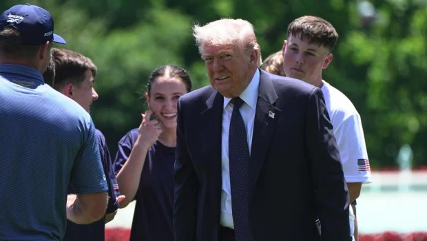 Trump regresa caminando hacia el Despacho Oval después de un encuentro con jóvenes en el jardín sur de la Casa Blanca.
