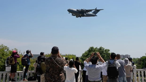 Varias personas filman un avión de transporte Boeing C-17 Globemaster III de la Fuerza Aérea de Estados Unidos a su llegada al Aeropuerto Internacional de Pekín, antes de la visita de Donald Trump.
