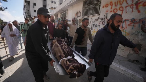Palestinos cargan con el cuerpo de una persona fallecida en ataques aéreos israelíes el viernes.