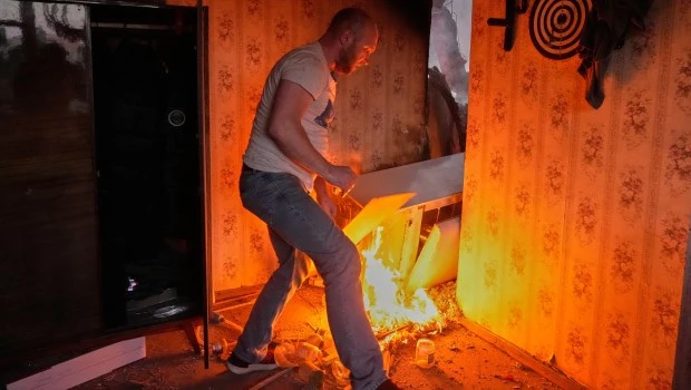 Un residente intenta apagar el fuego en su apartamento tras un intenso ataque aéreo ruso, en Kiev, Ucrania (24 de mayo de 2026).