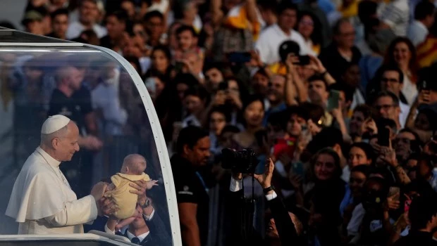 El papa recibió una estruendosa bienvenida en el estadio olímpico de Barcelona. A la derecha, un grupo de obispos durante esa vigilia de oración.