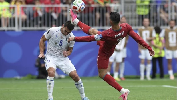 Cristiano Ronaldo (derecha), de Portugal, disputa el balón con Ashurmatov, de Uzbekistán, durante el partido de fútbol del Grupo K de la Copa Mundial de la FIFA 2026, disputado en el Estadio de Houston, Texas,