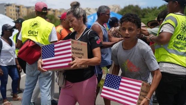 Personas afectadas por los terremotos llevan ayuda humanitaria enviada por EEUU.