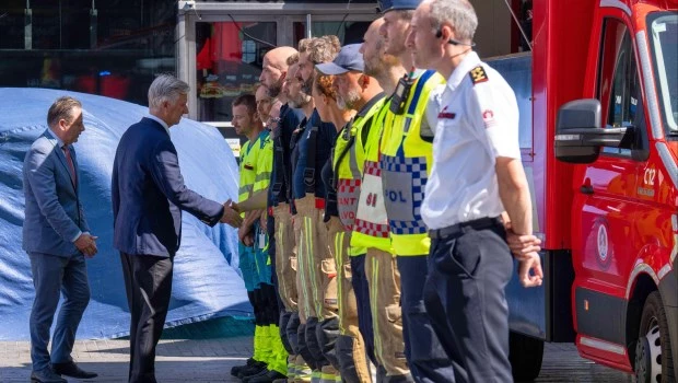El rey Felipe de Bélgica, segundo por la izquierda, y el primer ministro belga, Bart De Wever, a la izquierda, agradecen a los servicios de emergencia que acudieron al lugar tras un incendio en un complejo de edificios en el centro de Bruselas