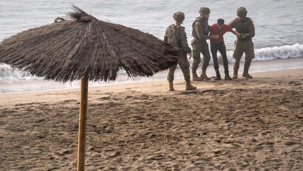 Soldados del ejército español ayudan a una persona que llegó a nado al enclave español de Ceuta, en el norte de África, desde Marruecos.