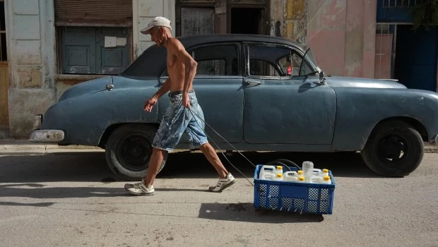 Un hombre tira de un carrito que transporta agua durante el apagón en La Habana.
