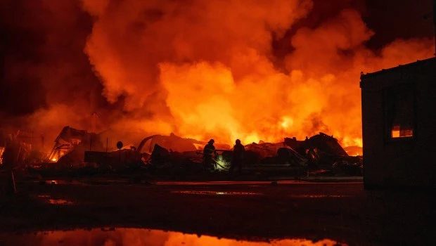 Bomberos intentan sofocar un incendio en un depósito tras un ataque con misiles ruso en Kiev.