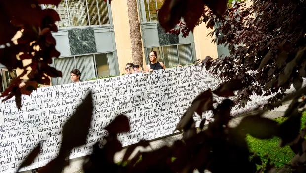 Lennon Torres, de Heat Initiative, sostiene un cartel con los nombres de jóvenes que, según los demandantes, murieron debido a las redes sociales.