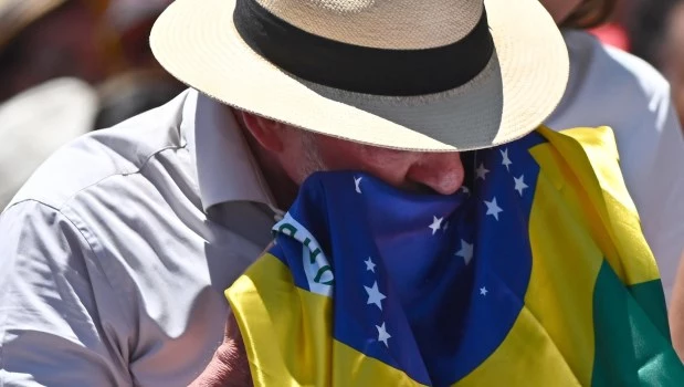 Lula besa la bandera de su país durante un acto de campaña en Brasilia.