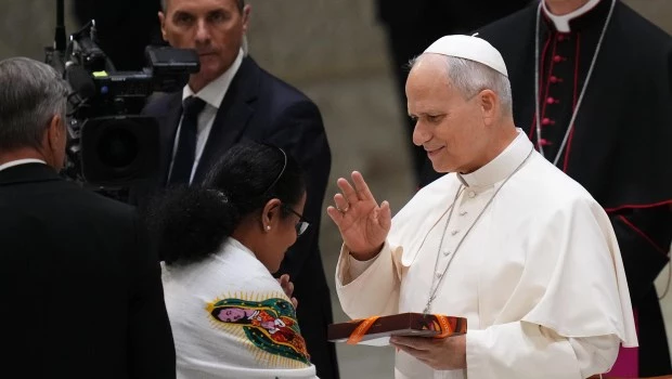 León XIV bendice a una mujer al finalizar una audiencia con los participantes de la Conferencia Internacional de la Juventud de Jesús en el Aula Pablo VI.