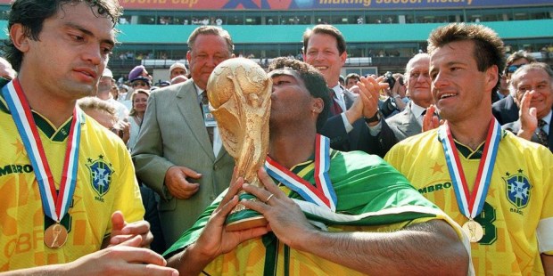 Romario besa la Copa del Mundo ante la mirada de Branco y Dunga.