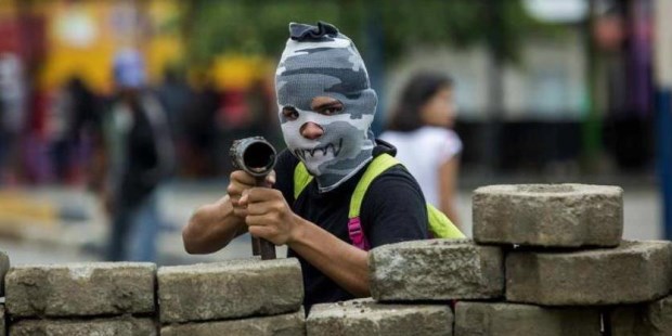 Un joven con la cara tapada y un lanza morteros en una barricada en la ciudad de Masaya (Nicaragua) .